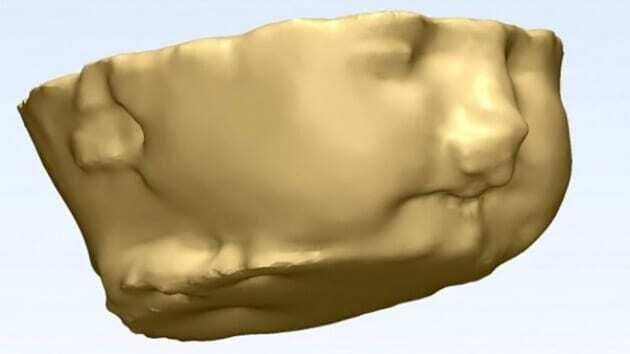 Molde impresso em 3D da face do Bebê Conan. Fundo azul claro com modelo a cor bege. Continue lendo nosso post!